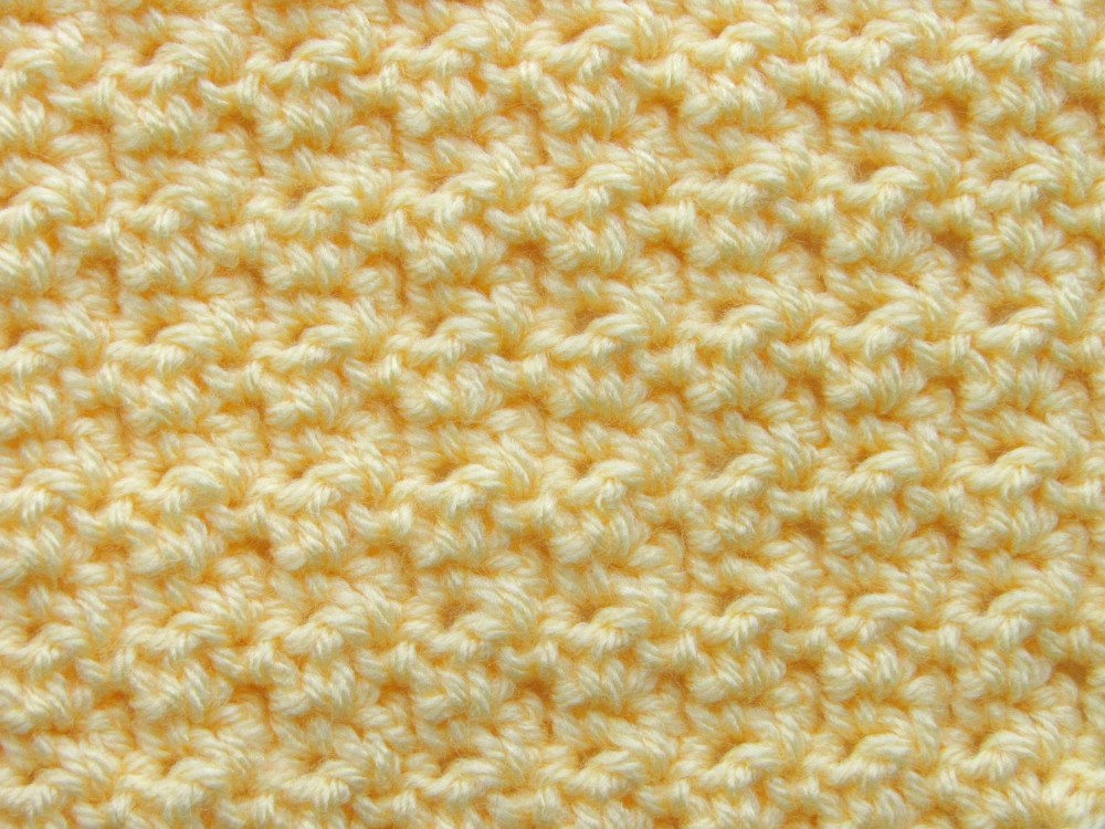 close up picture of the c2c lemon peel stitch made of yellow yarn