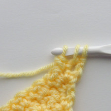 the fourth step of the scdc crochet decrease, where there is a yarn over pulled through the first two loops on the hook